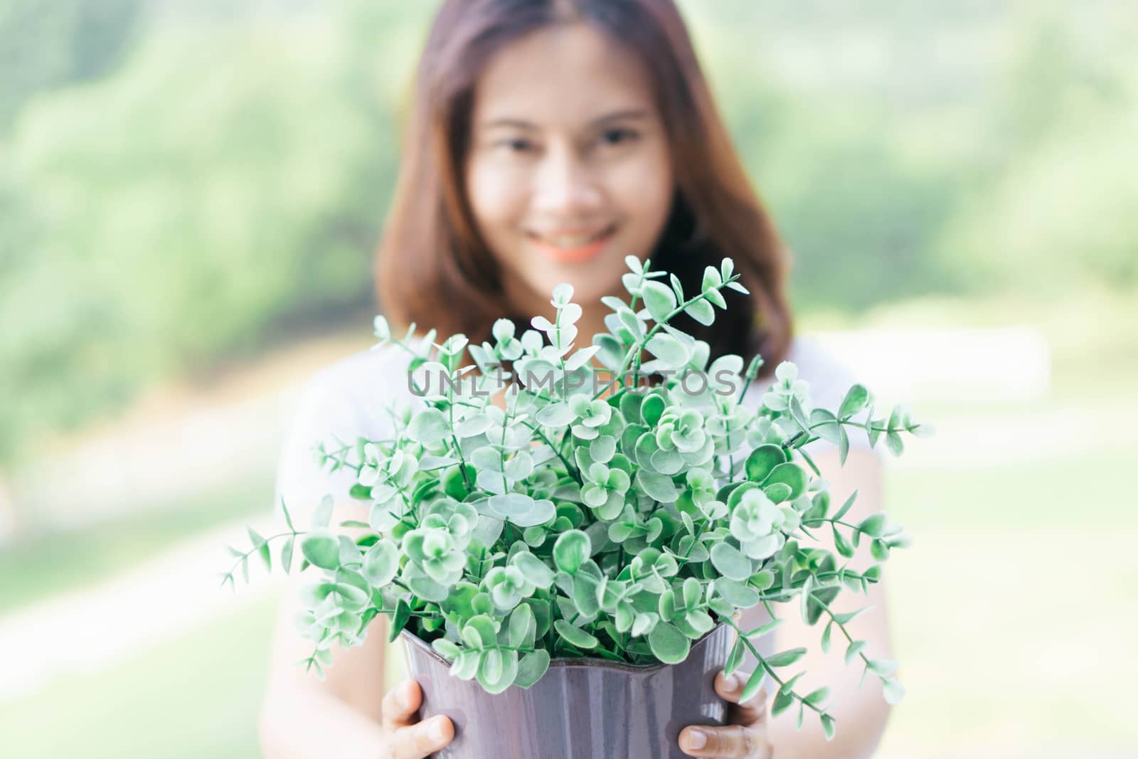 Closeup woman touching tree in pot with happy face in the morning