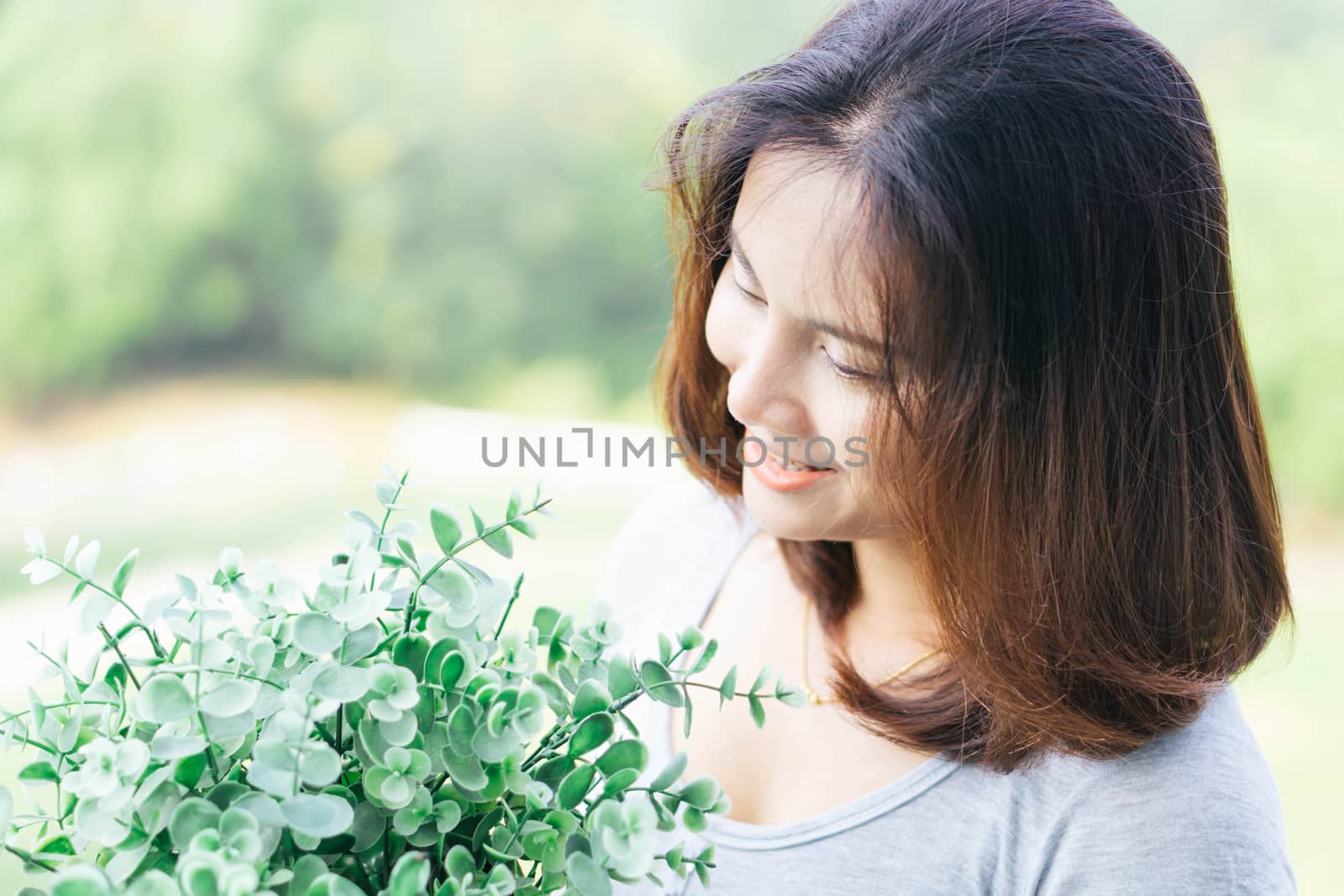 Closeup woman touching tree in pot with happy face in the morning