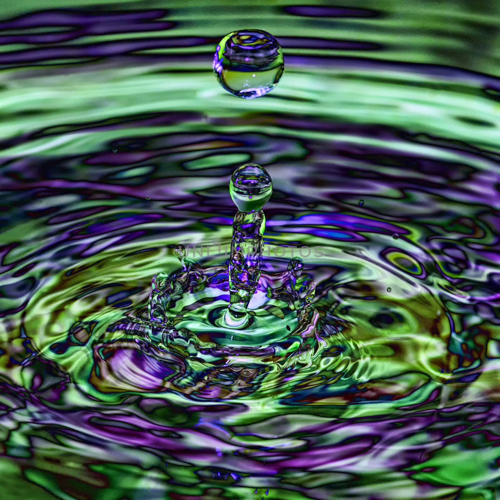 Water splash, droplet with a multi coloured blue green iridescent transparent ripple splash 