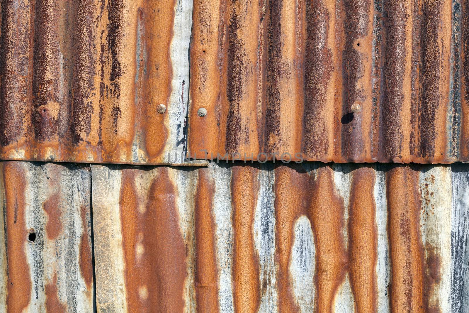 Distressed old corrugated rust covered iron fence texture background