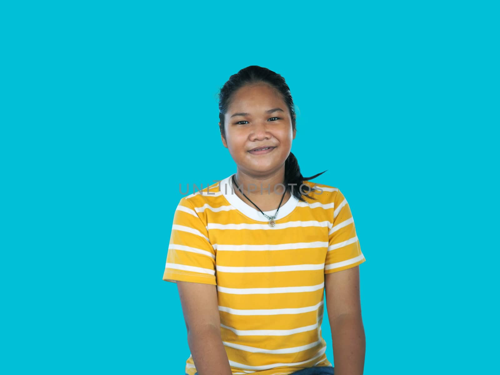 Portrait of Asian woman In a yellow shirt isolated on a blue background.
Happy people concept.