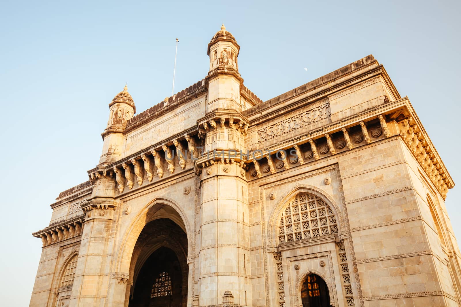 Mumbai, India - 9 November: The Gateway of India with tourists and sellers on a clear autumn evening