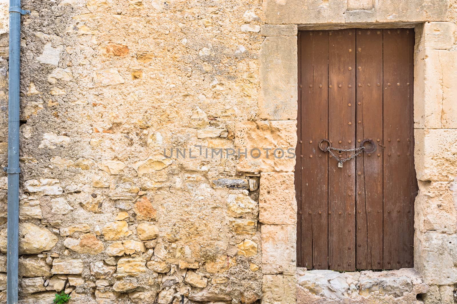 Close-up of old house stone wall and brown wooden door
