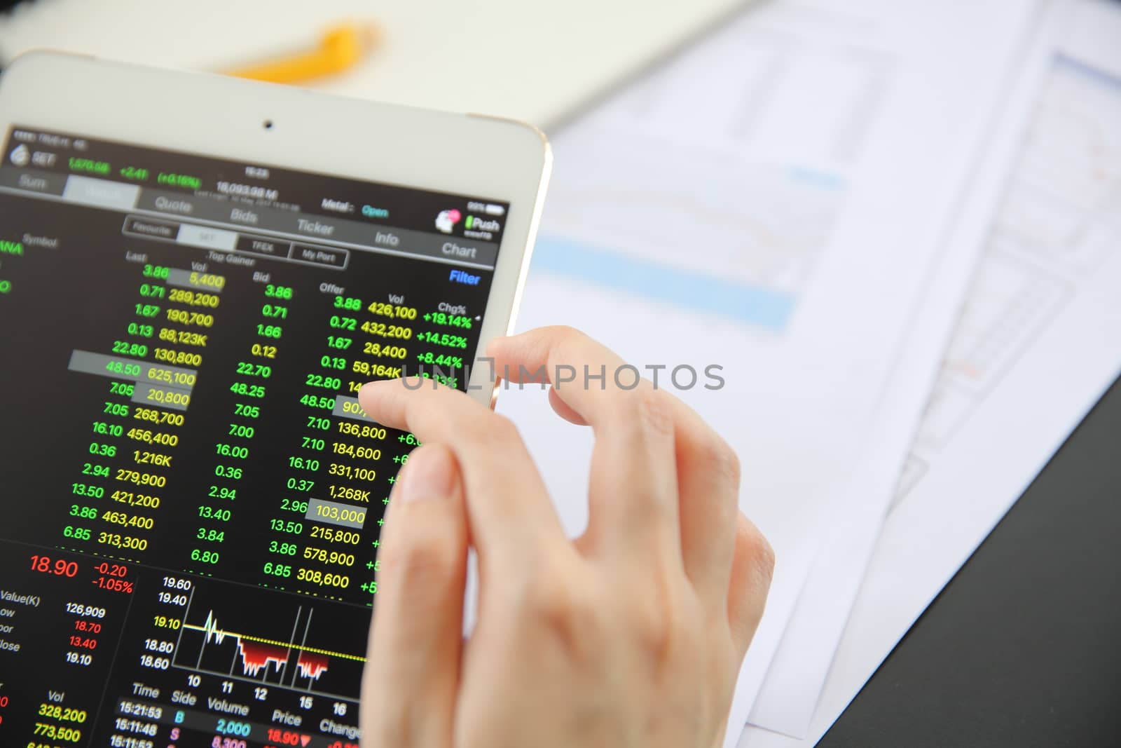 Woman hand Trading online on tablet with business paper and coffee