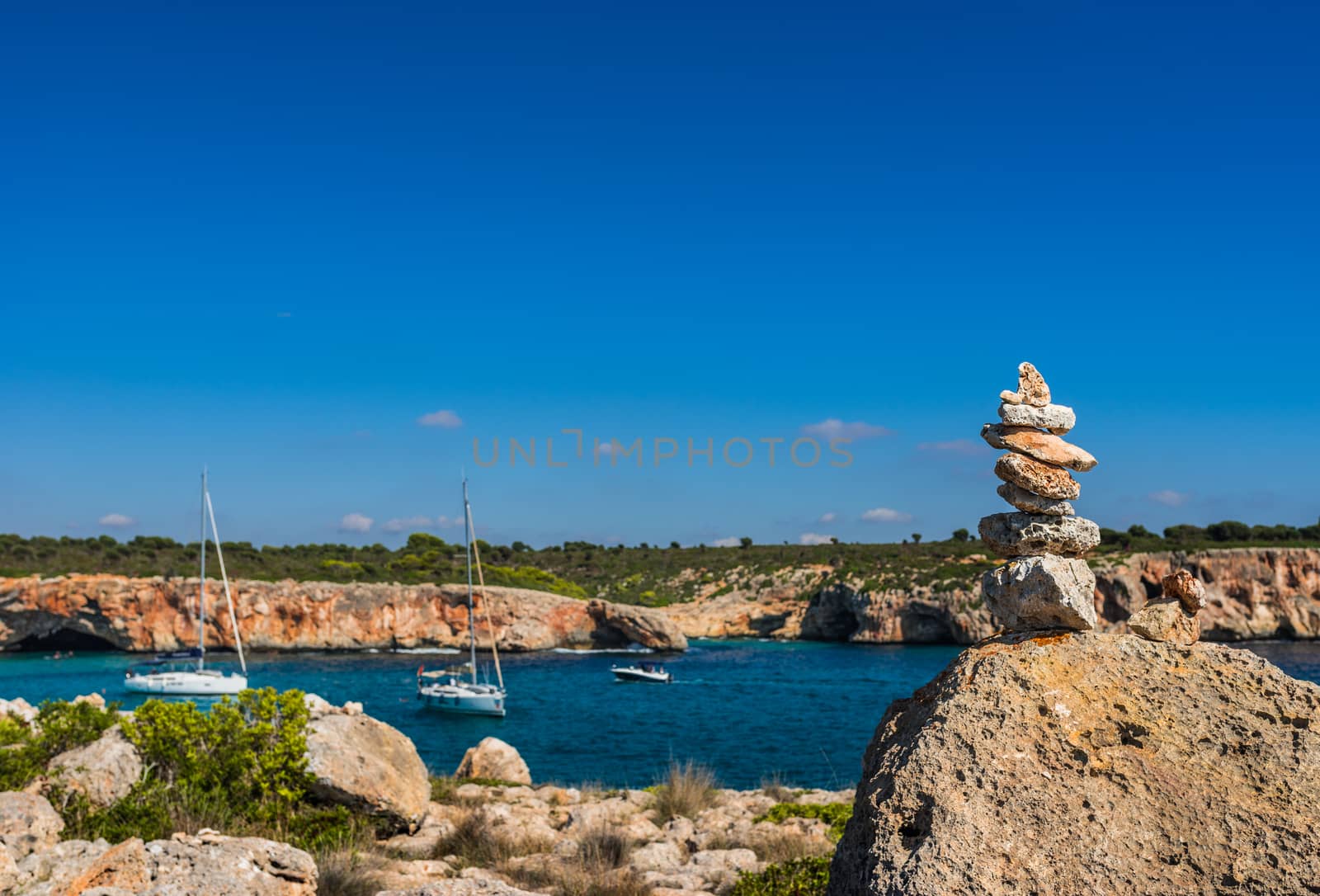 Idyllic bay with boats and stone stack at the coast of Mallorca, Spain Balearic Islands