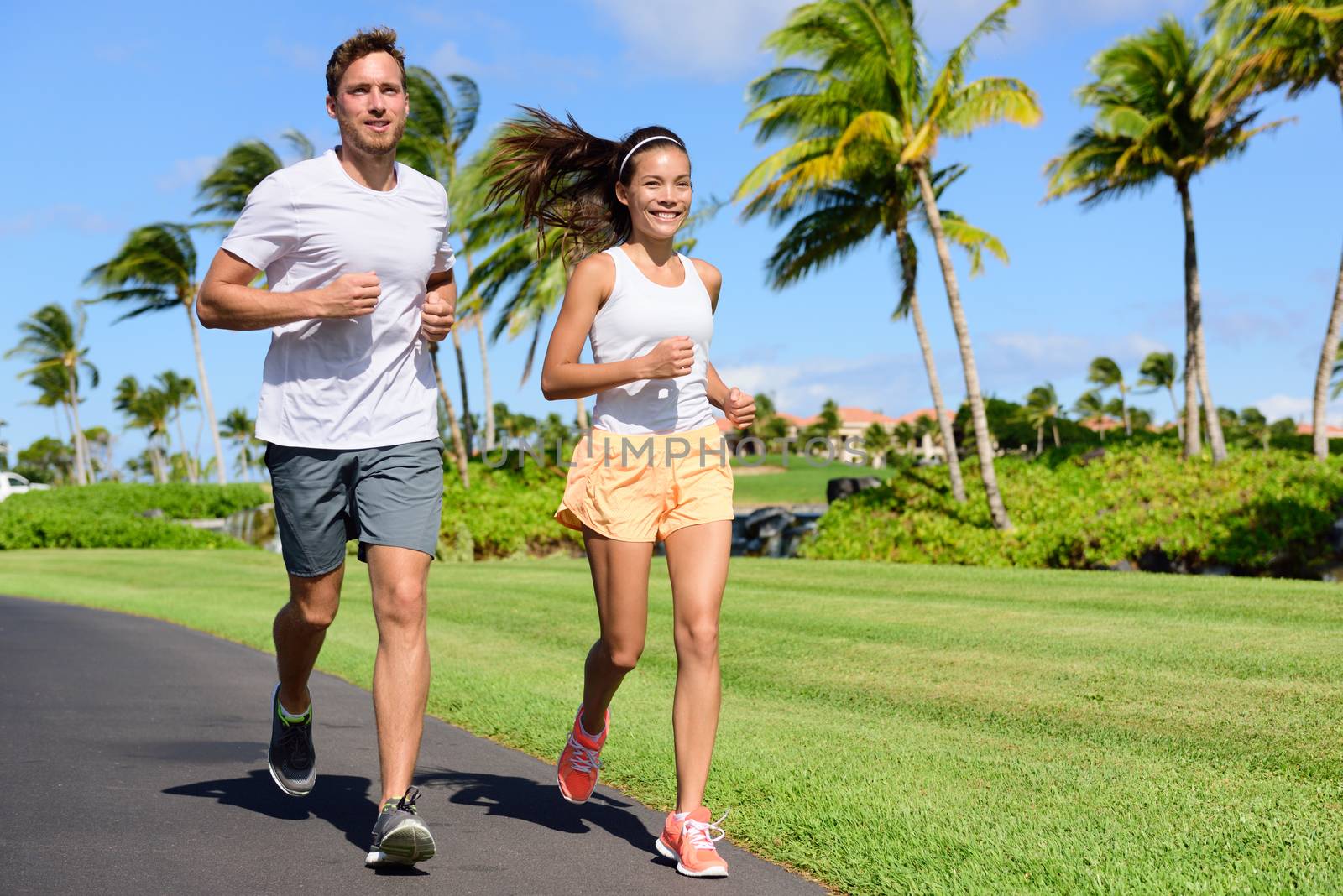 Sport couple exercising running outside on street by Maridav