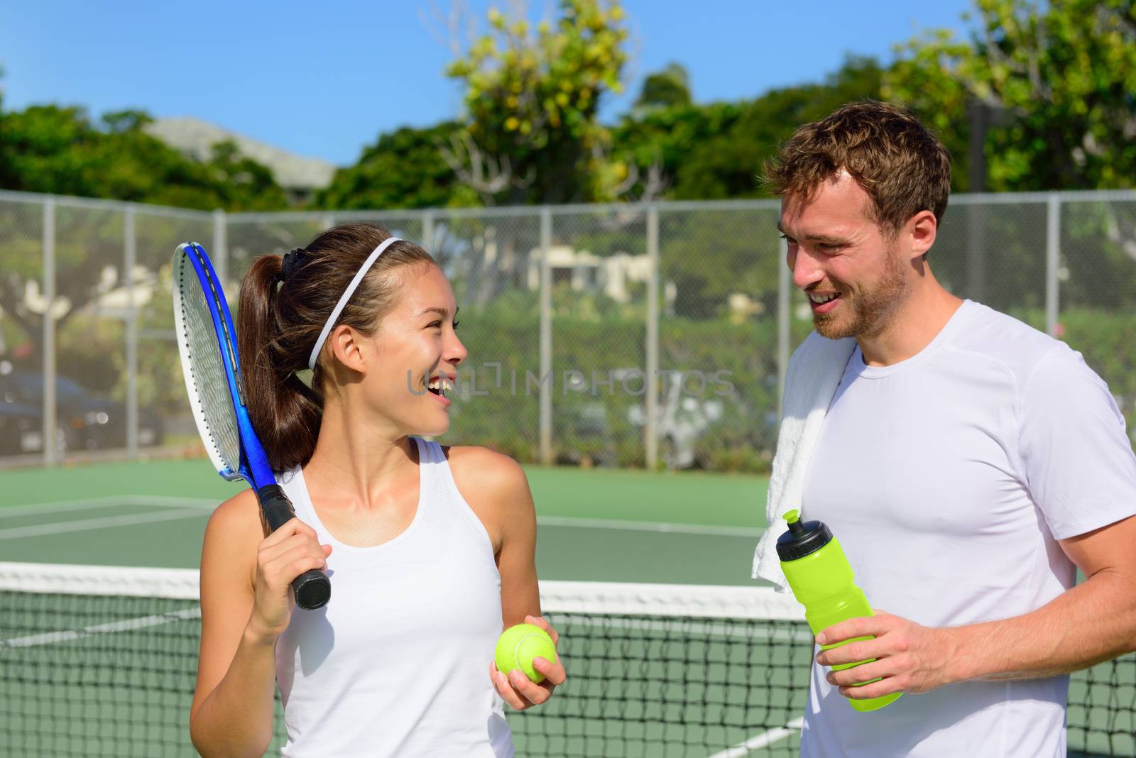 Tennis sport - couple relaxing after playing game by Maridav