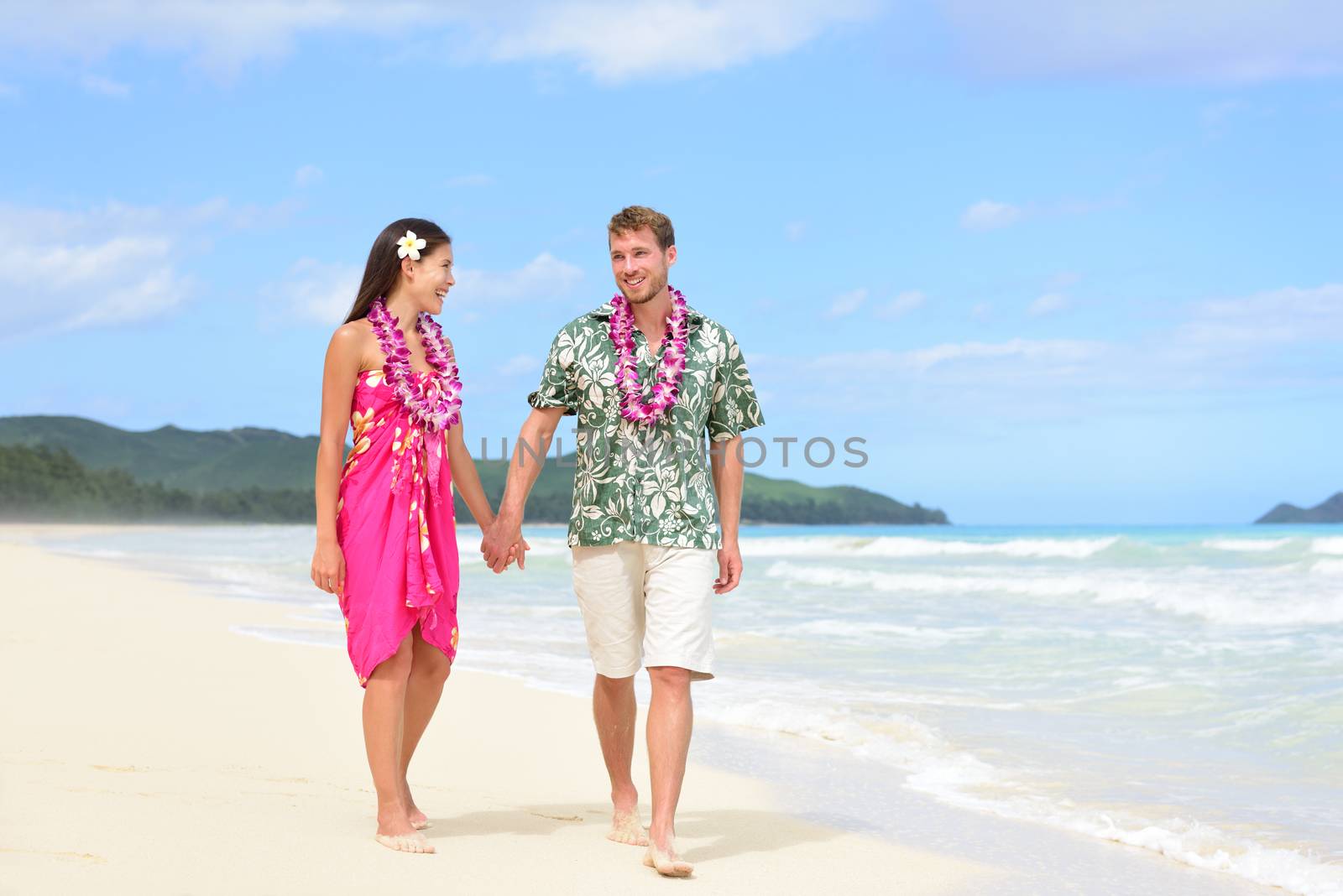 Beach couple on Hawaii vacation with Hawaiian leis by Maridav