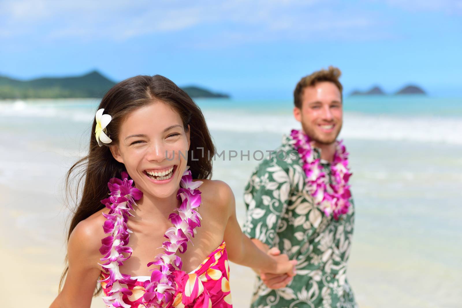 Happy Hawaii beach holiday couple in Hawaiian leis by Maridav