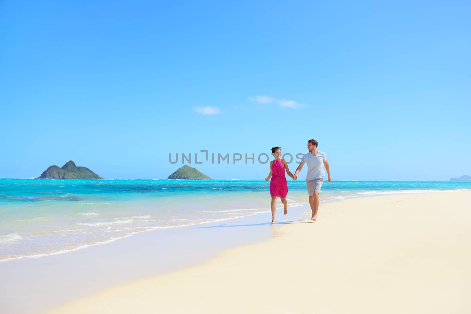 Beach couple happy having fun on Hawaii honeymoon by Maridav