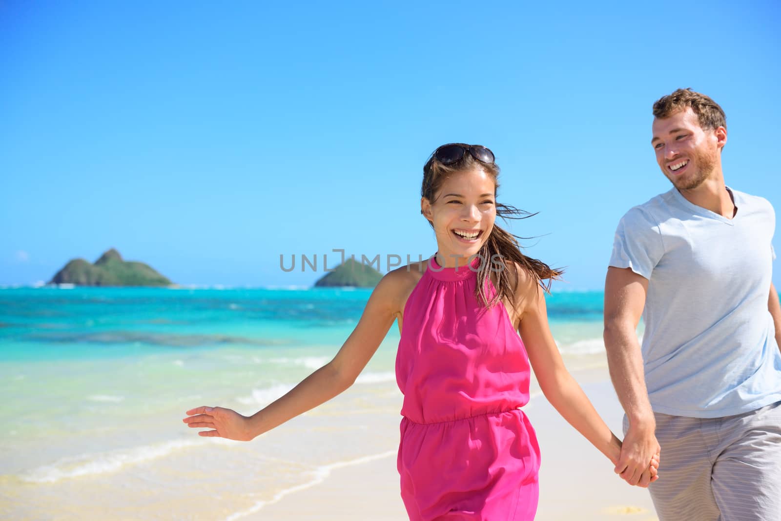 Happy couple on beach running having fun on Hawaii by Maridav