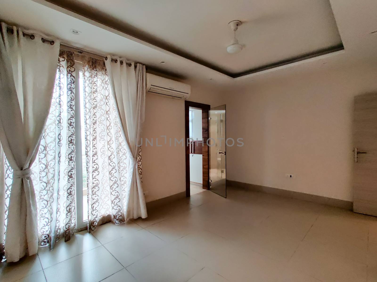 Wide angle shot of a ready to move in apartment with lace curtains and good natural light. Shot at a modern expensive beautifully maintained flat or apartment in Delhi, Gurgaon, Noida for premium individuals. Shows the real estate of India