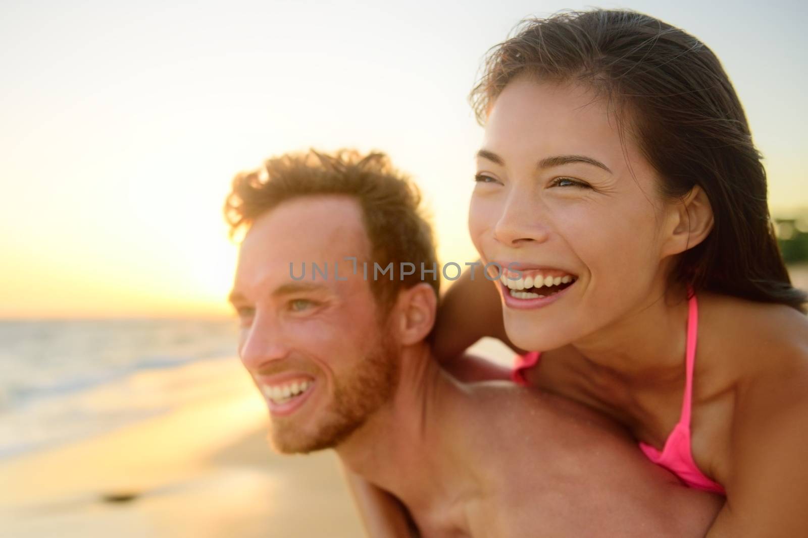 Beach couple laughing in love having fun romance by Maridav