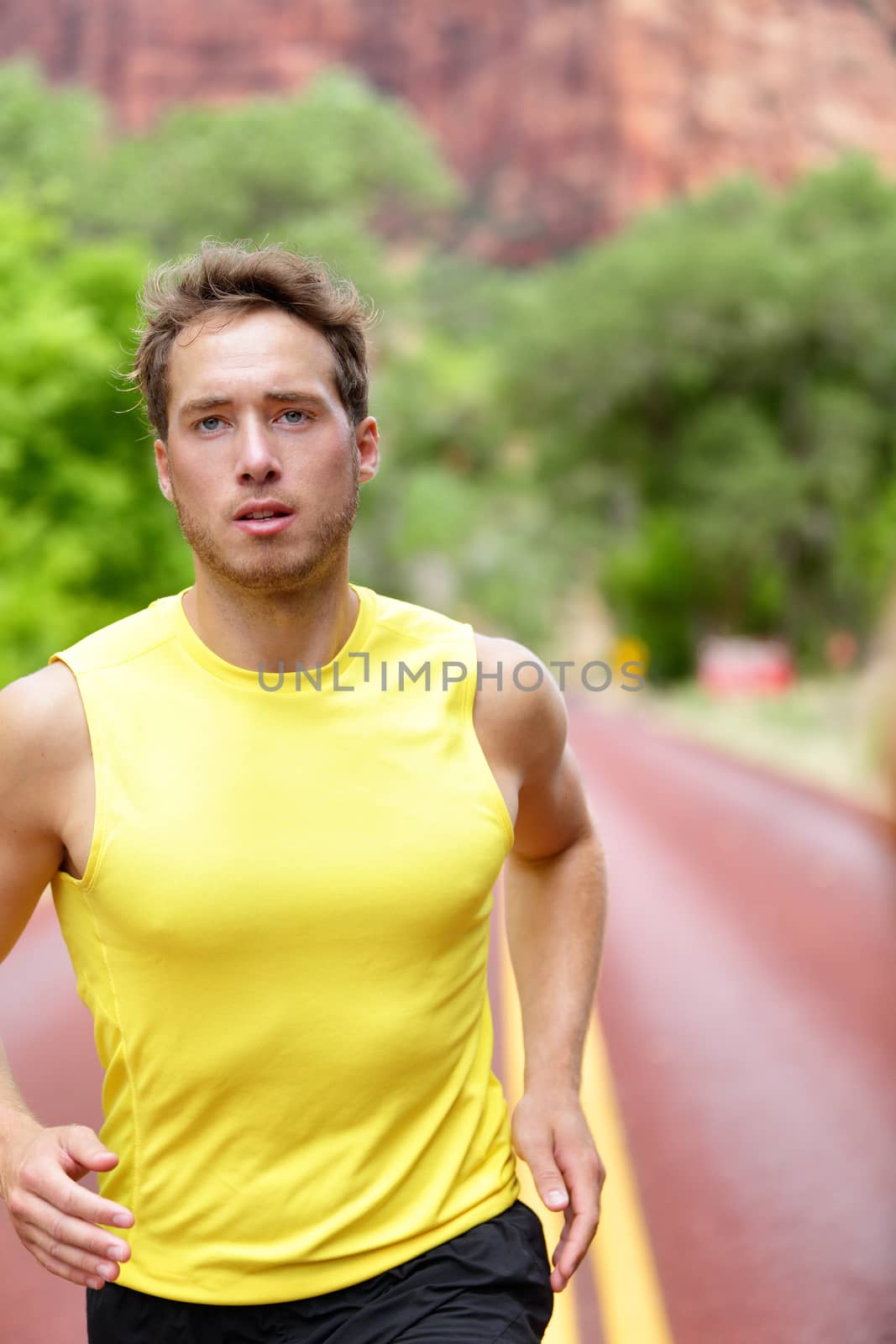 Fitness sport runner man running determined and focused with concentration training for success and health. Male athlete in sprint run in workout for marathon.