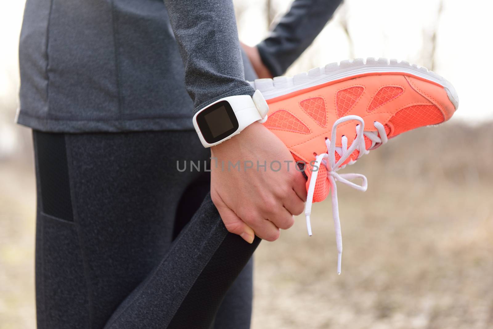 Running stretching - runner wearing smartwatch by Maridav