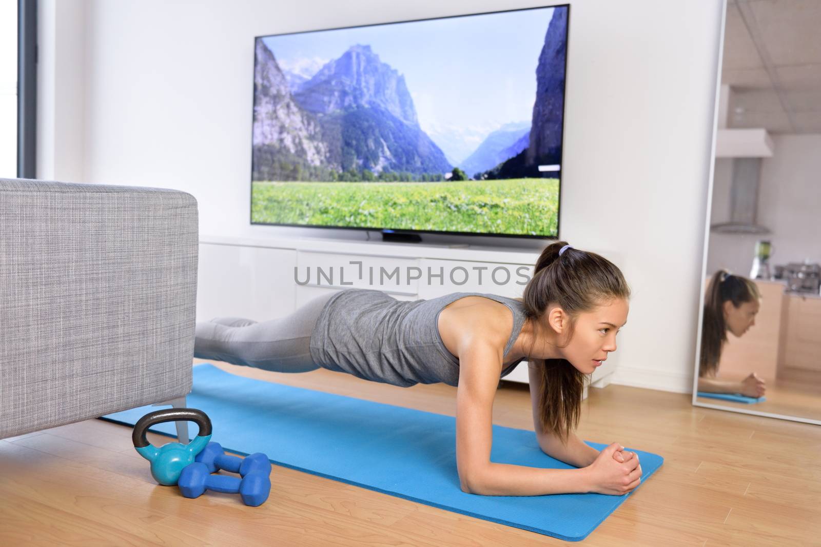 Living room exercises - girl doing plank at home by Maridav