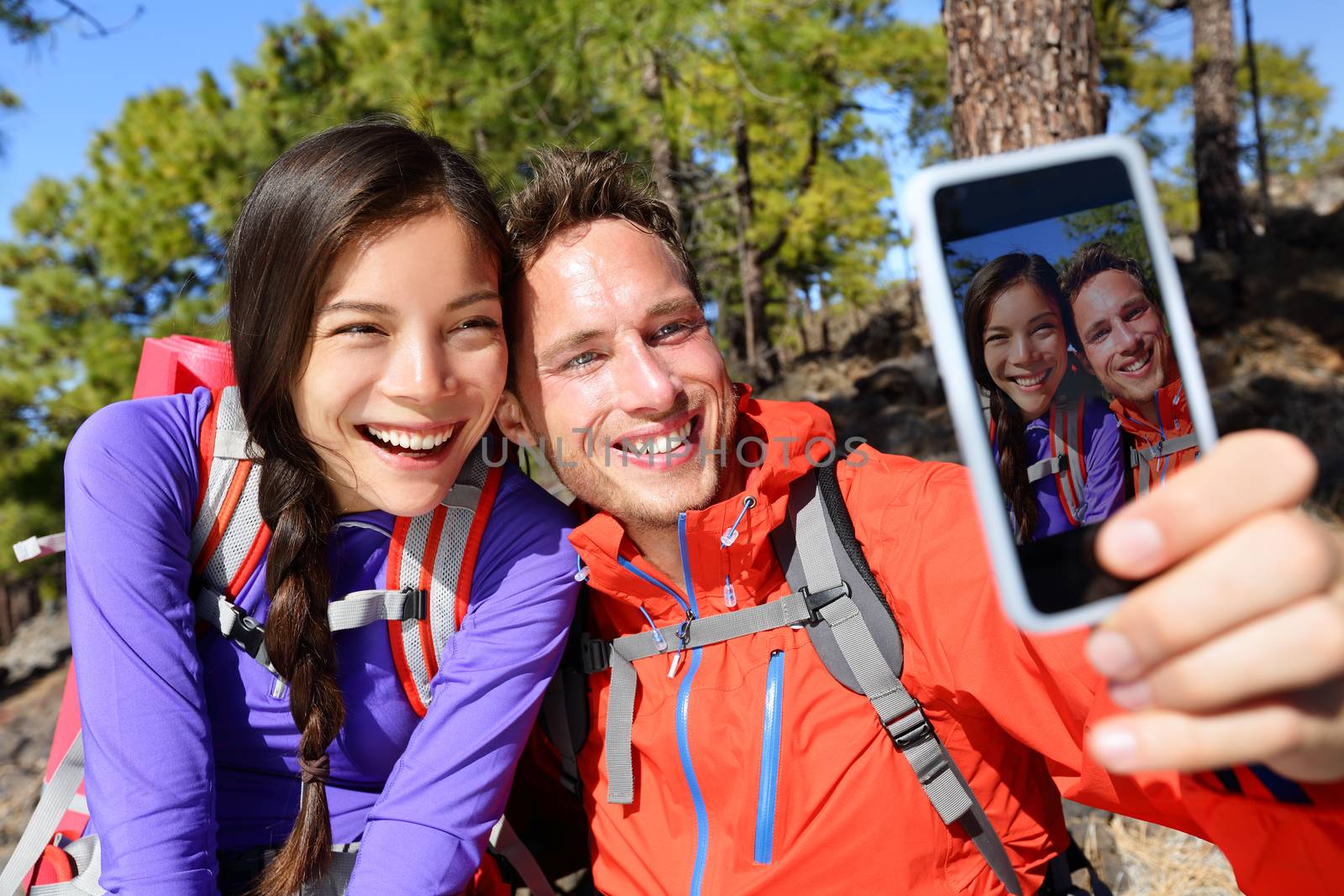 Happy friends hikers taking selfie on hiking trip by Maridav