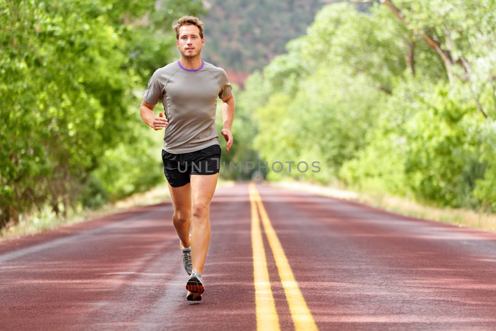 Sport and fitness runner man running on road by Maridav