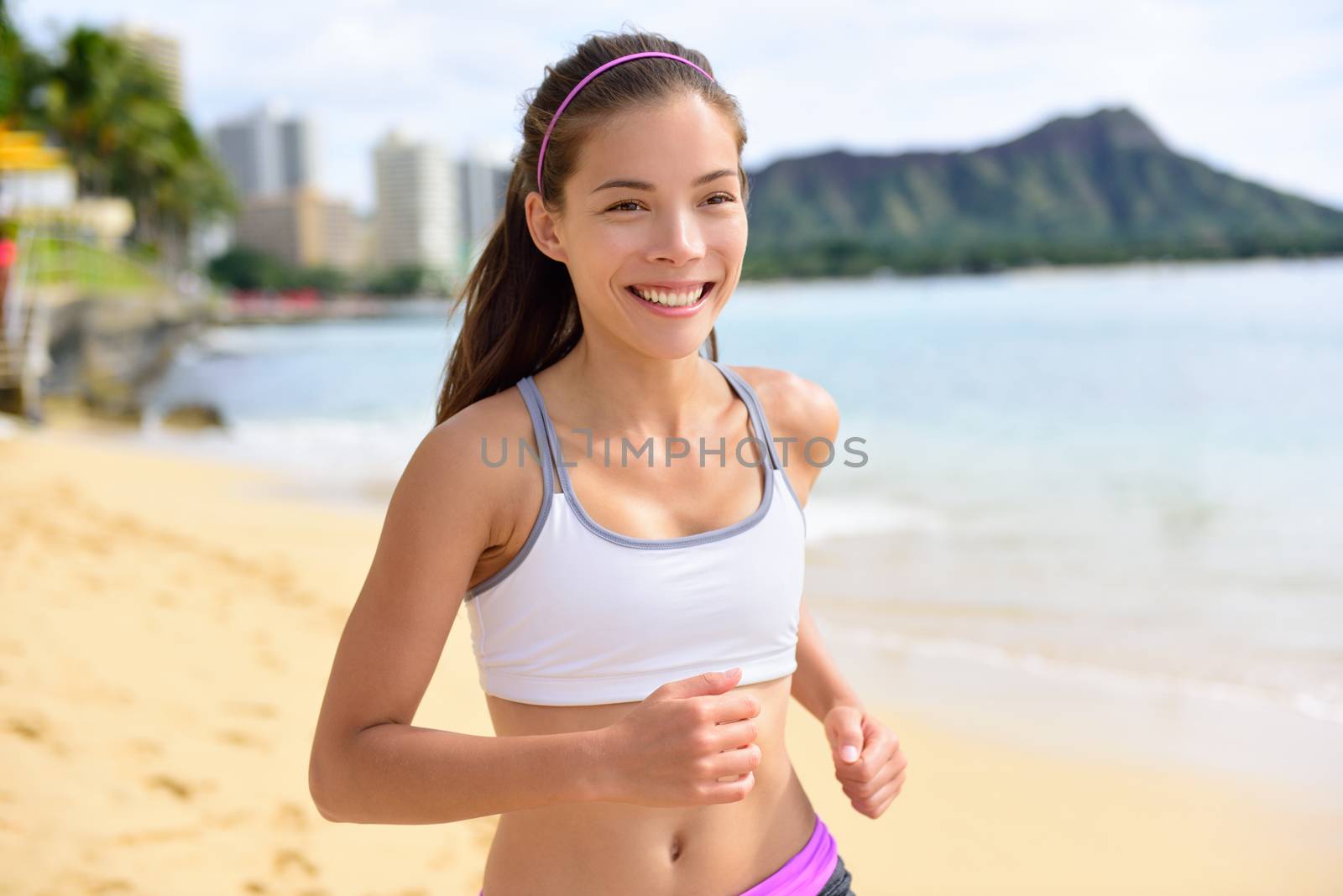 Running sport fitness woman jogging on beach run. Female athlete runner jogger training living healthy active exercise lifestyle exercising outdoor on Waikiki Beach, Honolulu, Oahu, Hawaii, USA.