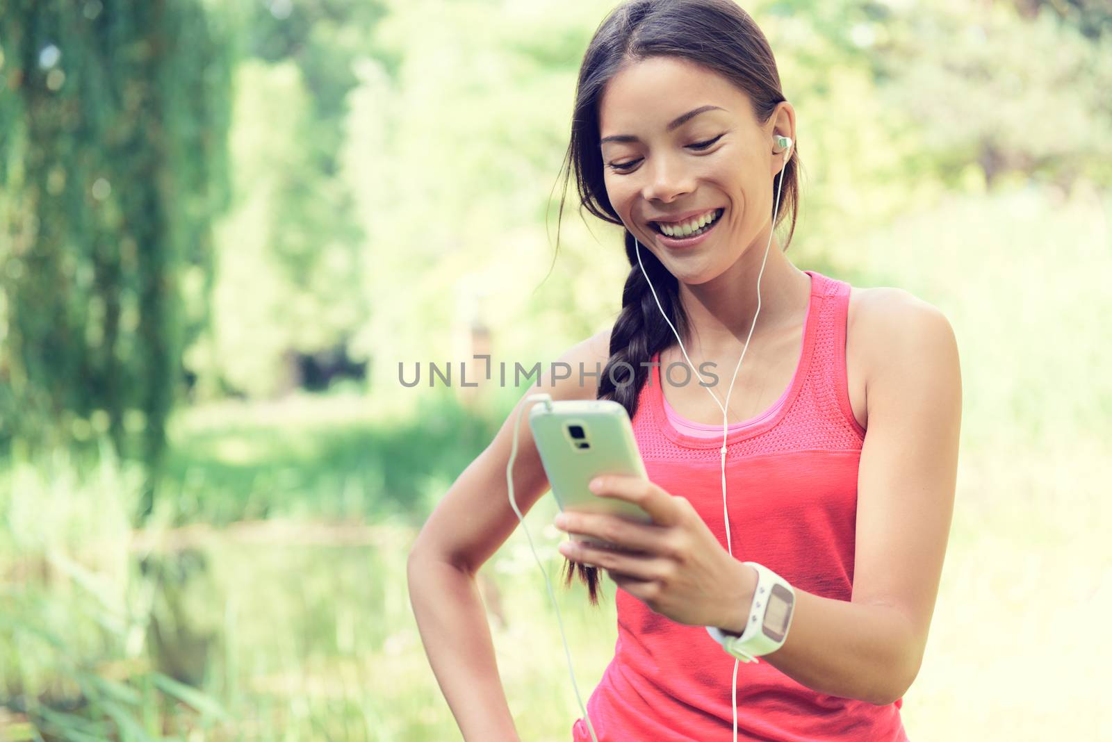 Fit Woman Using Cell Phone While Listening Music by Maridav