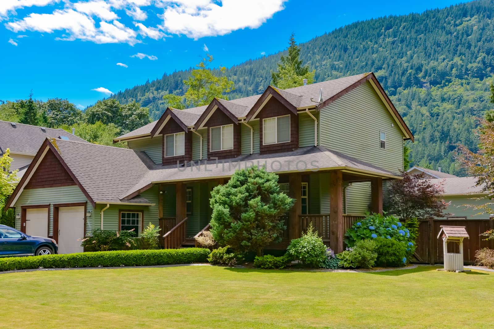 Big family house with  draw-well decorating the front yard on mounting and blue sky background