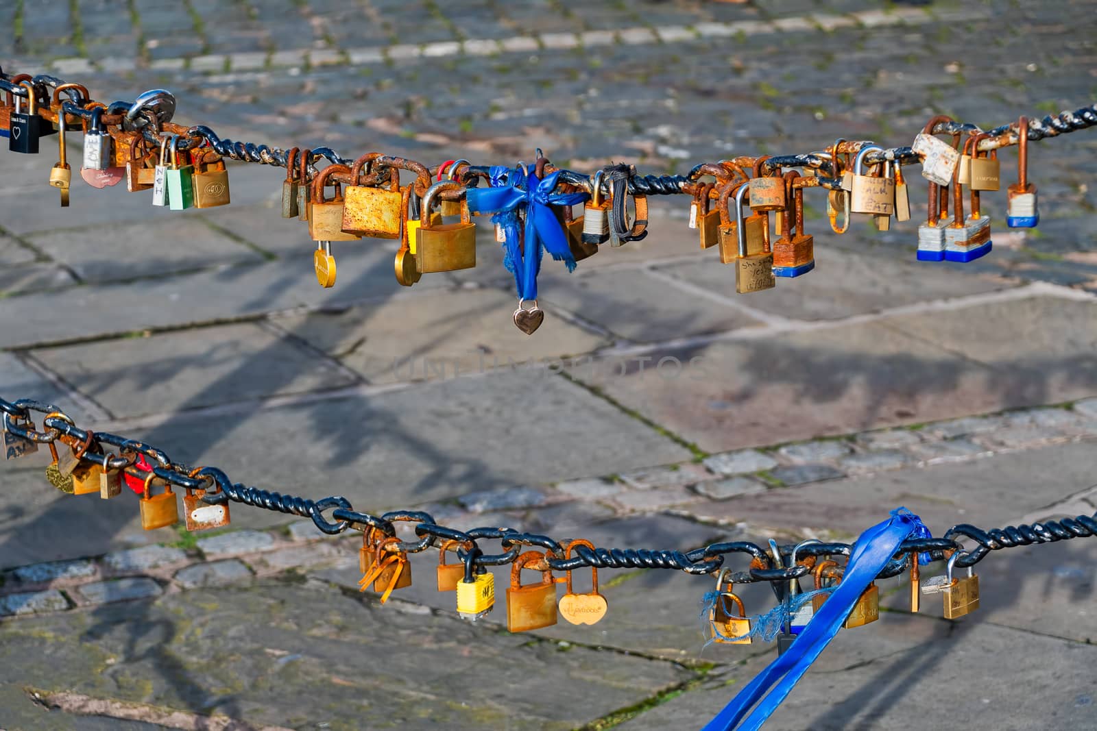 Old rusty Love Lock padlocks attached to a chain fence