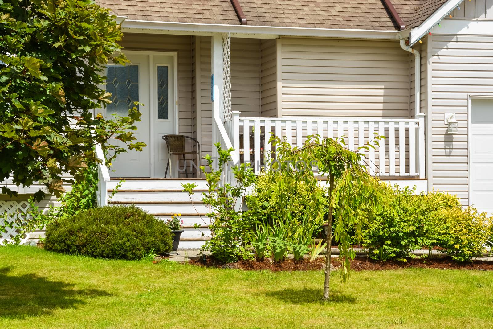 Entrance and porch of residential house with landscaping in front