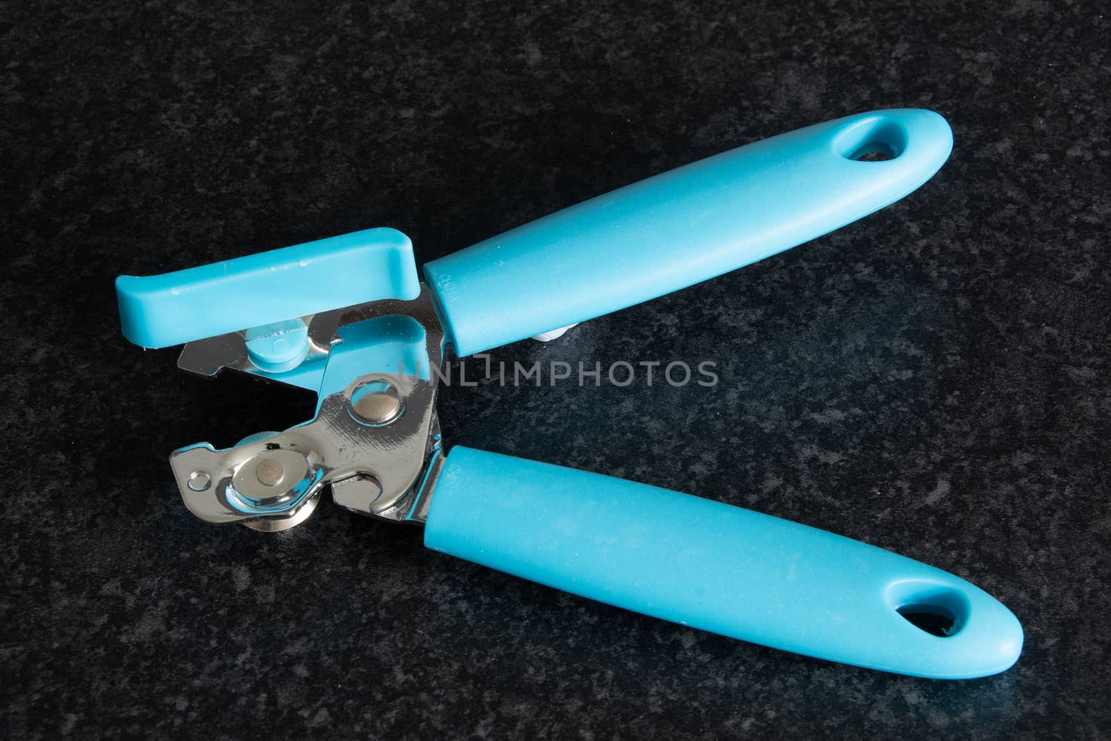 Blue coloured can opener on a dark background