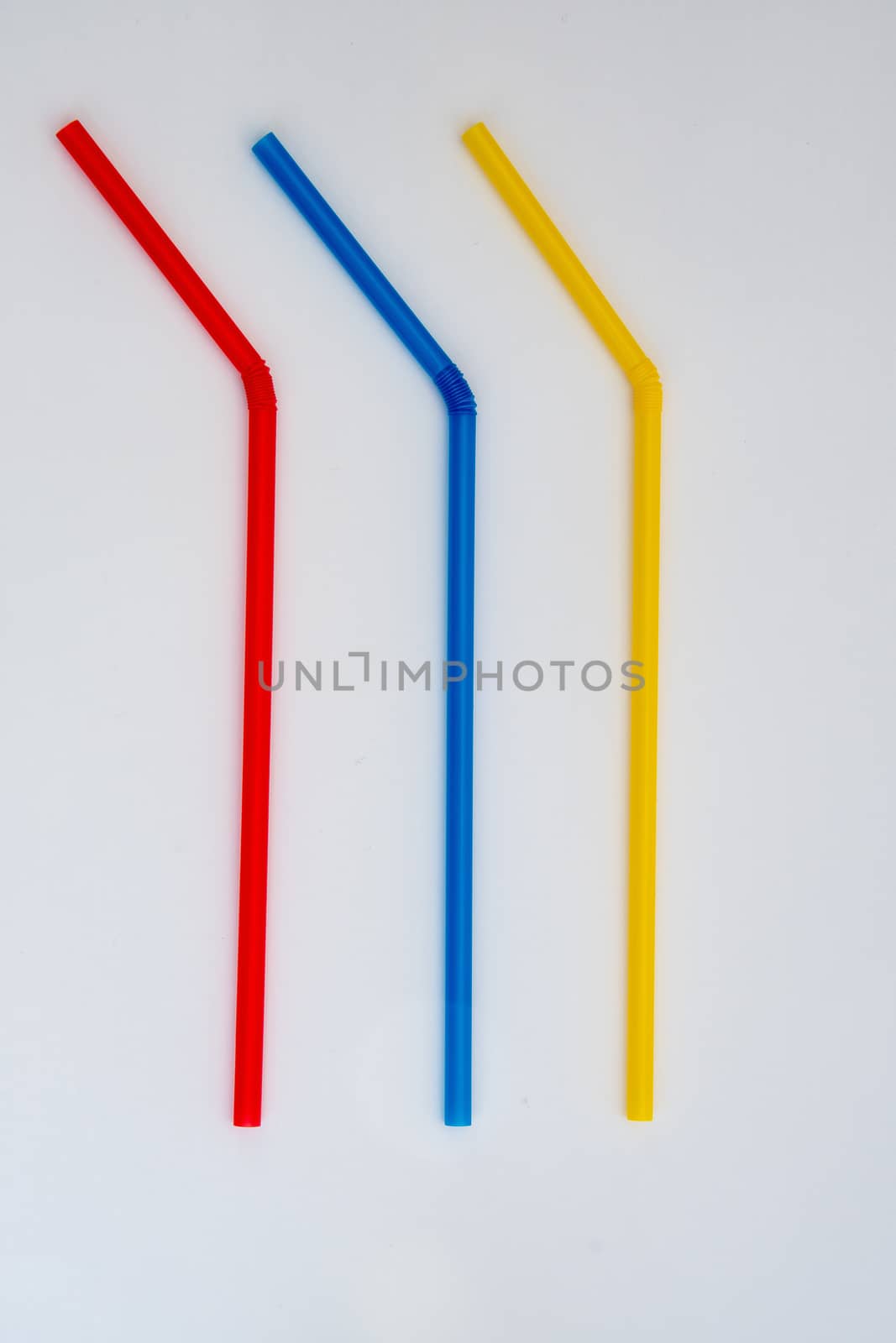 Three different coloured plastic drinking straws