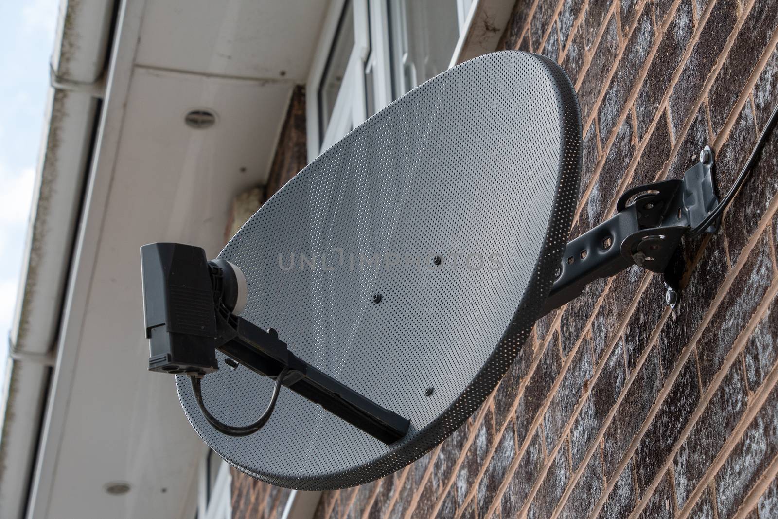 TV satellite disk mounted on a brick wall by Russell102