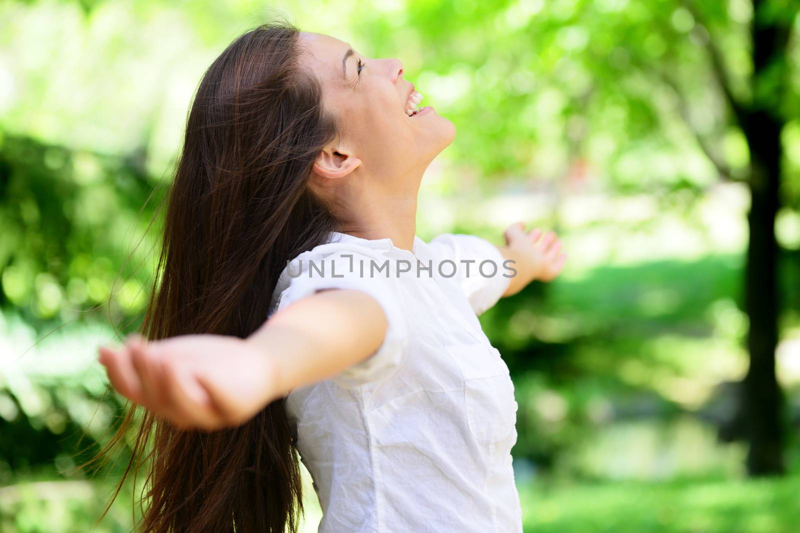 Joyful Woman With Arms Outstretched In Park by Maridav