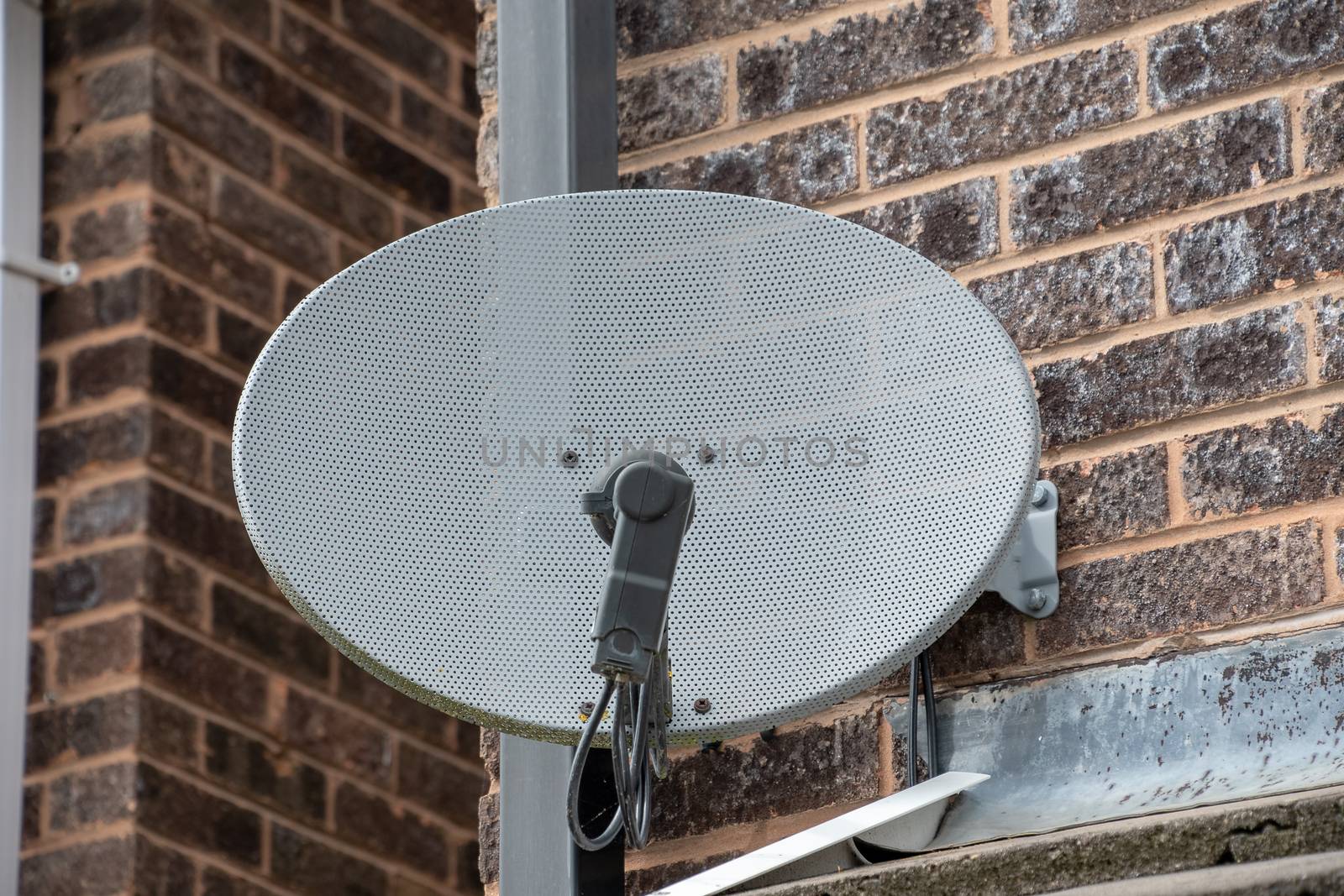 TV satellite disk mounted on a brick wall