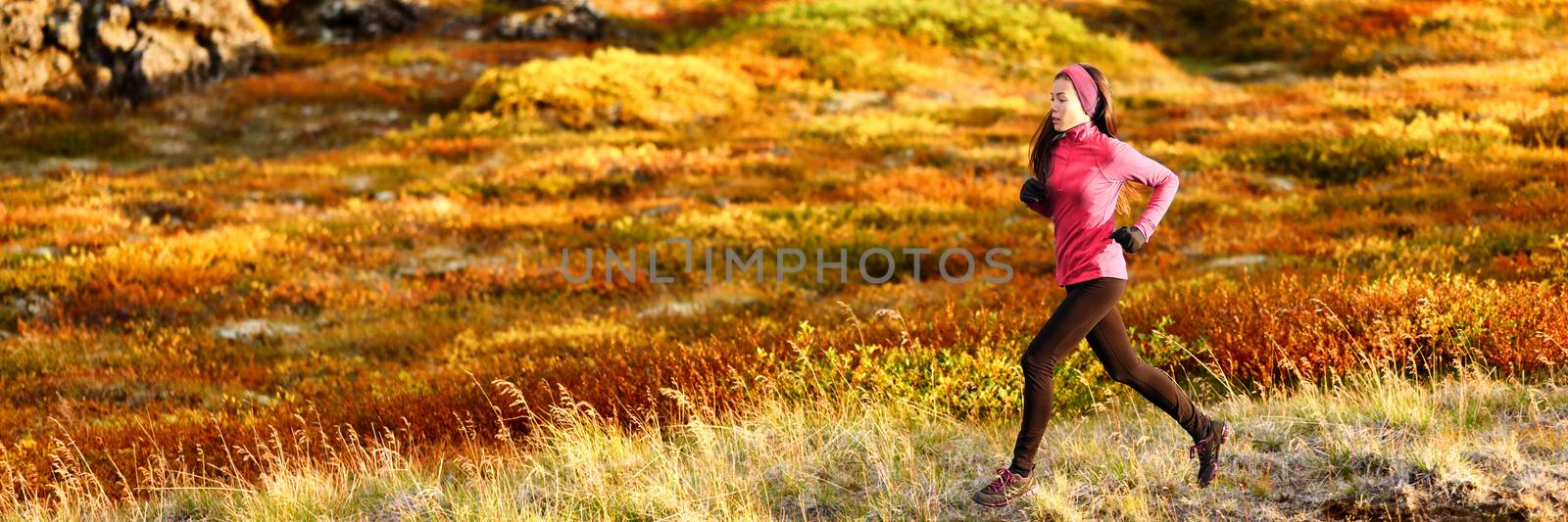 Healthy active lifestyle trail running athlete woman training outdoors doing cardio exercise in autumn foliage background. Panoramic banner.
