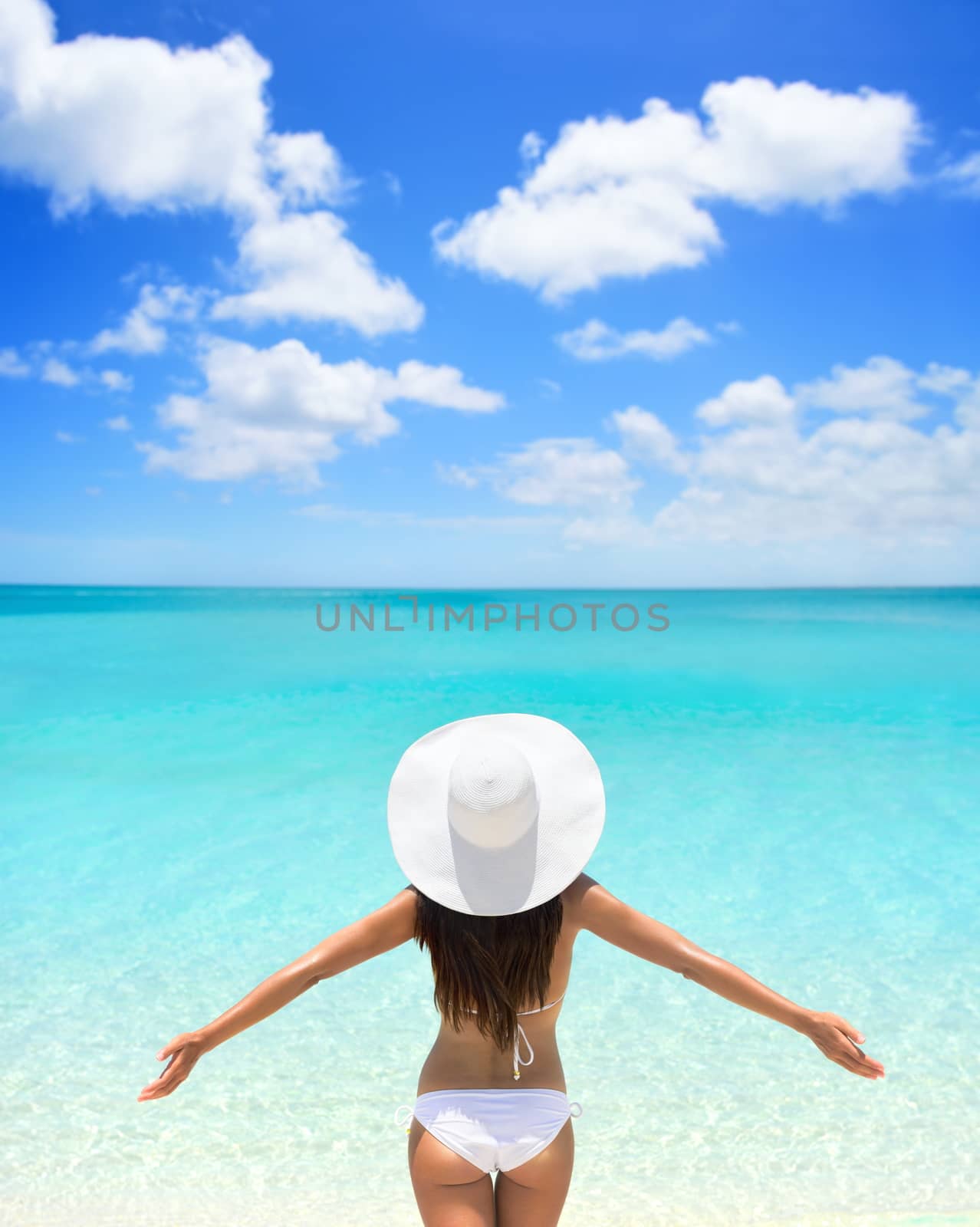 Carefree Woman In White Hat And Bikini On Beach by Maridav
