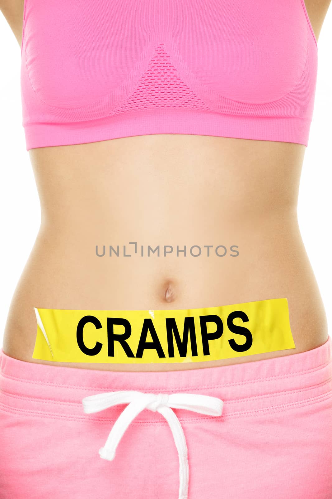 Midsection of woman with cramps sign stuck on stomach. Young female is representing stomach ache concept. Woman is wearing pink sports bra. She is isolated over white background.