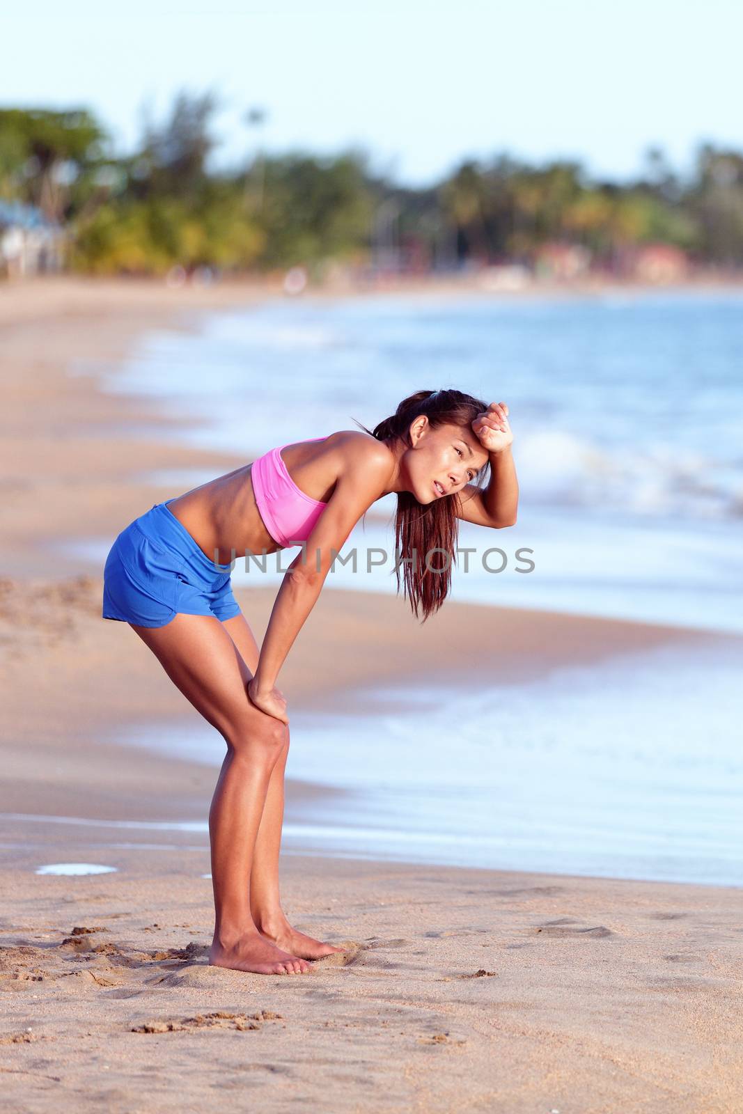 Tired Female Runner Bending On Beach After Running by Maridav