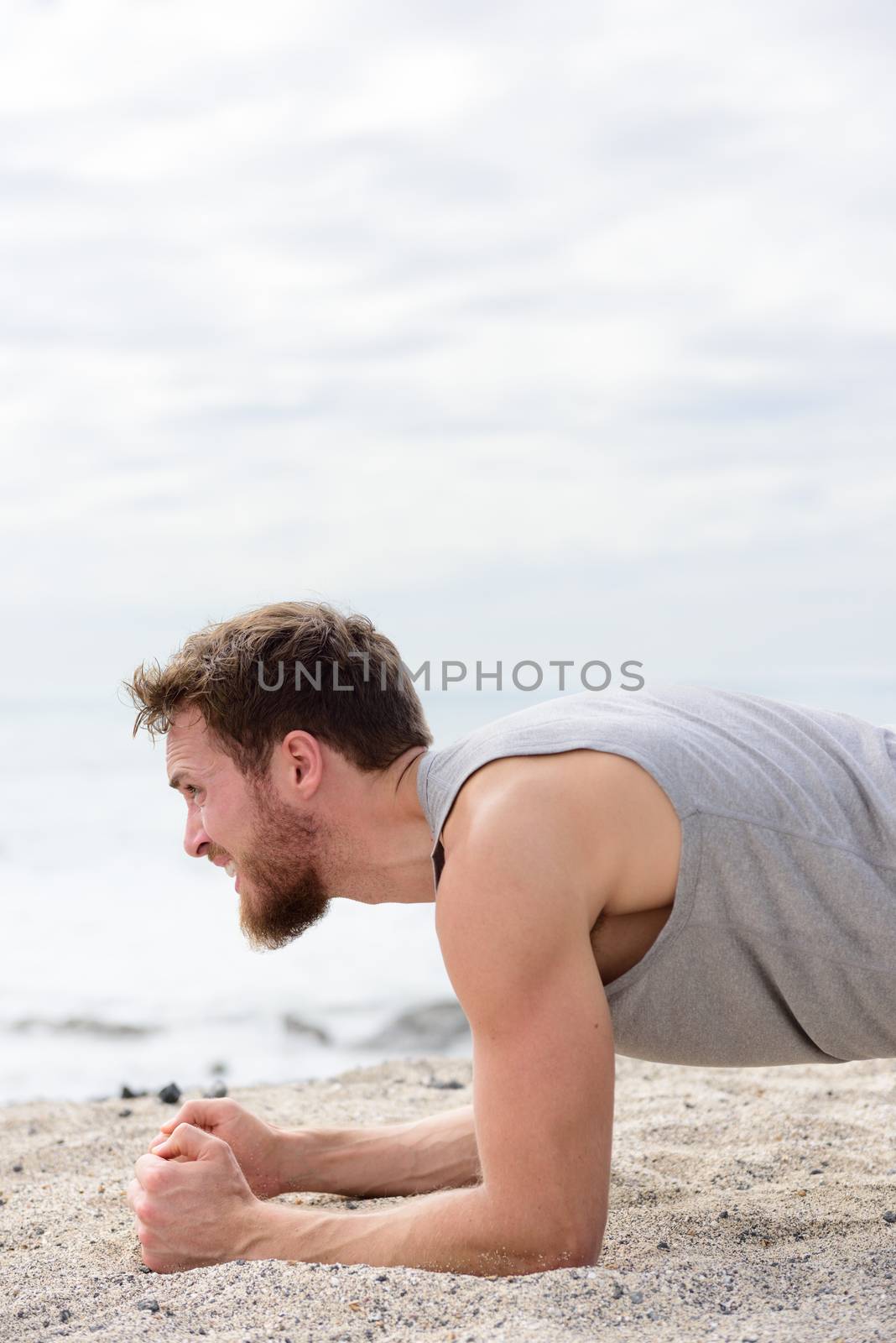 Core body workout fitness man doing plank exercises. working out his midsection muscles. Fit athlete fitness cross training planking exercising outside in summer on beach sand. by Maridav