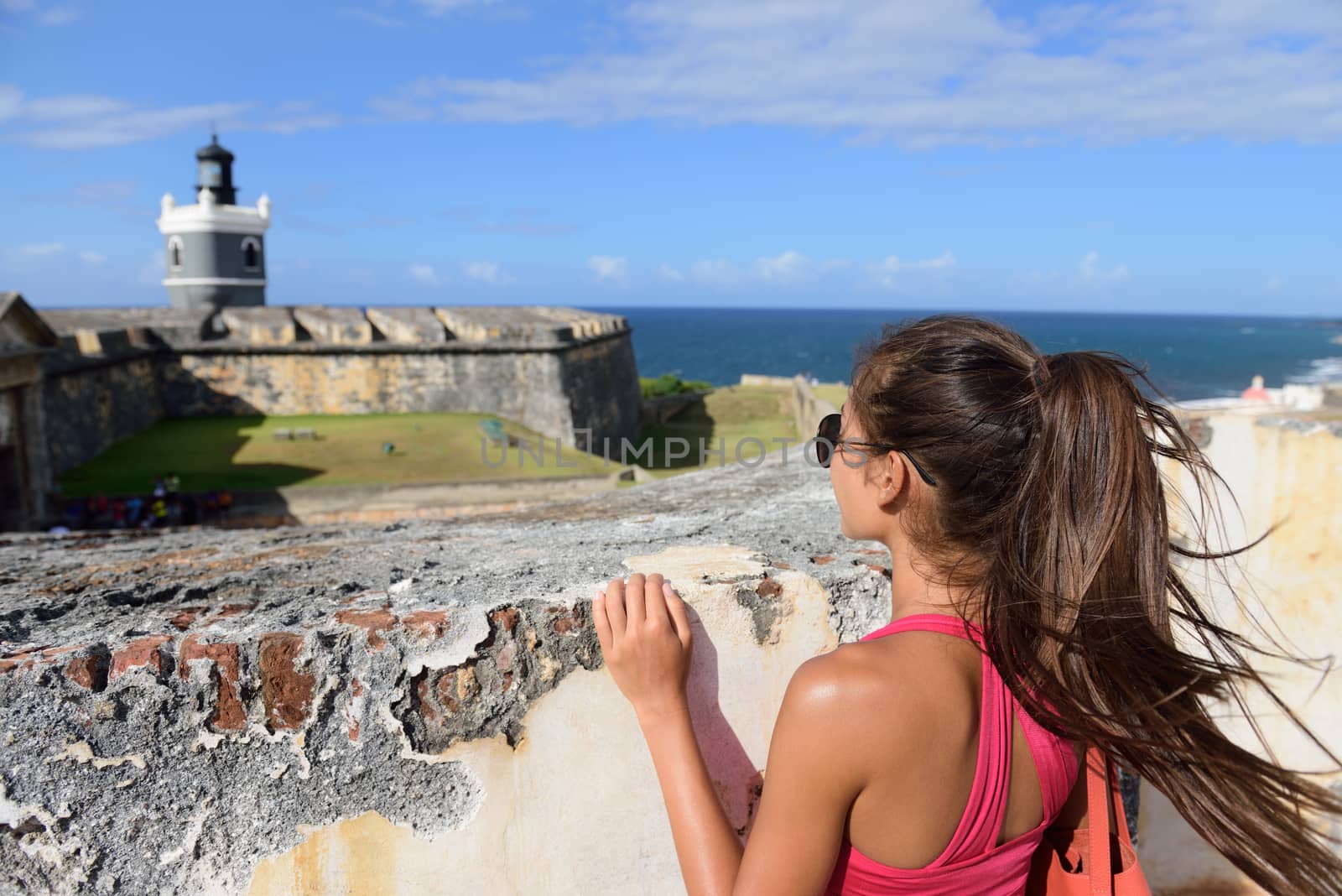 Puerto Rico travel tourist woman in San Juan, looking down at the fort Castillo San Felipe Del Morro, famous attraction of Old San Juan city in Puerto Rico, USA. Summer holidays.