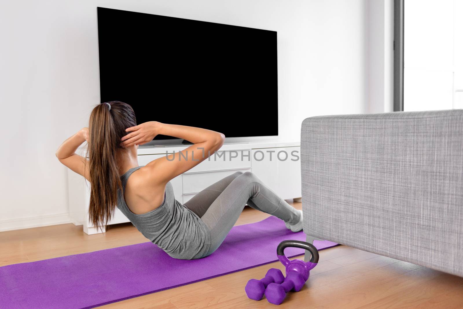 Home fitness woman watching workout videos on tv by Maridav