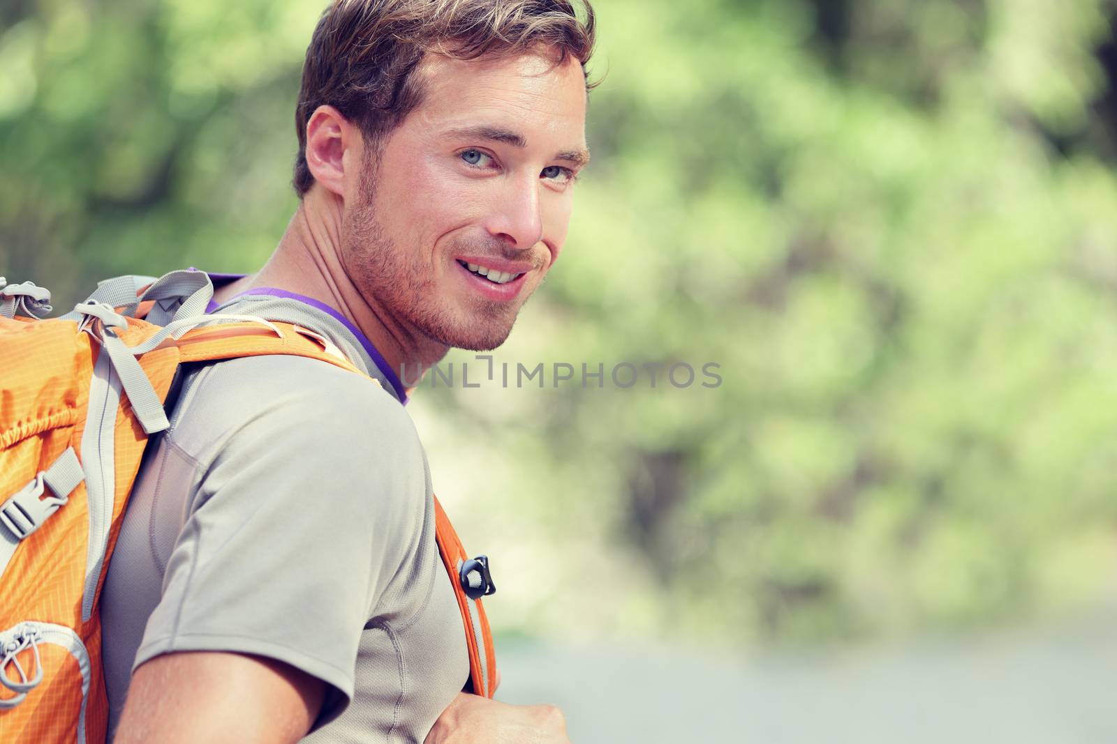 Young smiling backpack man in summer forest nature by Maridav