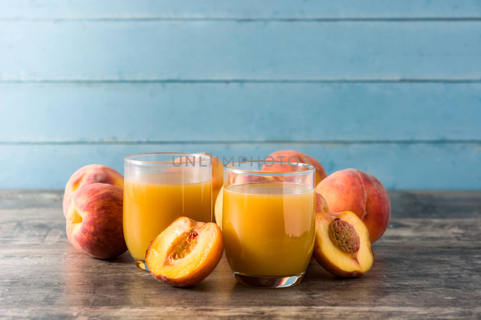 Natural peach juice in glass on wooden table