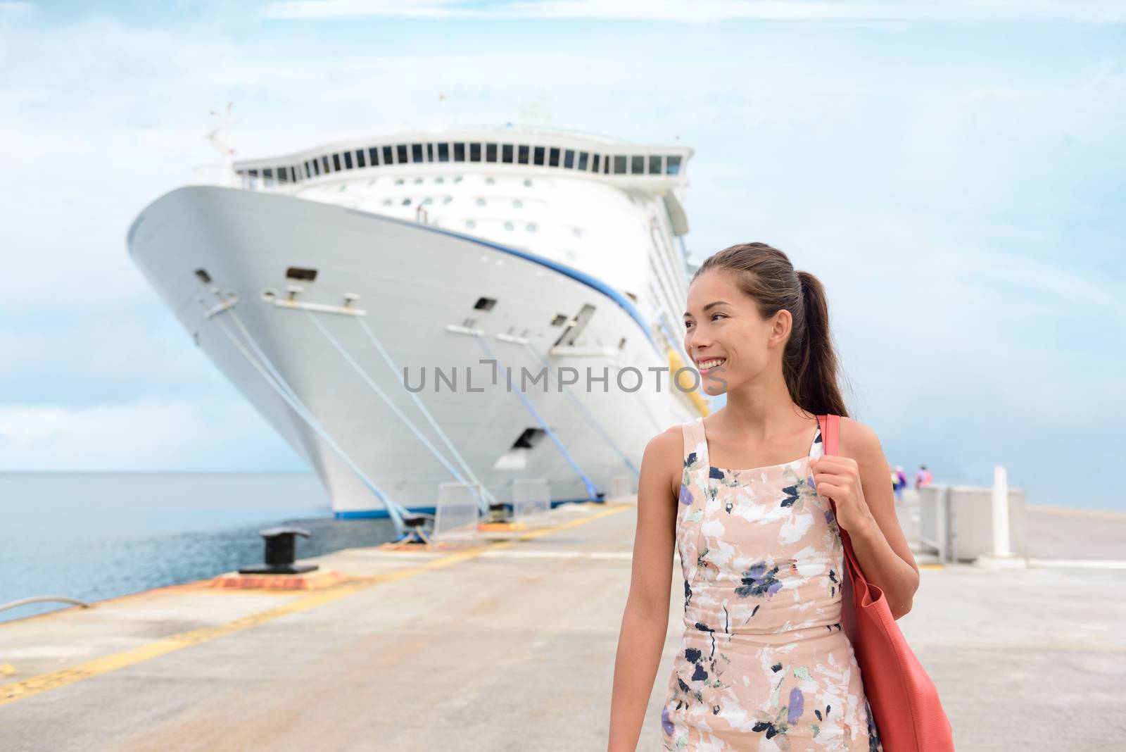 Cruise Ship Vacation Happy Female Tourist on Pier. Smiling happy young woman walking on pier by huge cruise ship moored at jetty. Beautiful woman in casuals is enjoying her vacation.