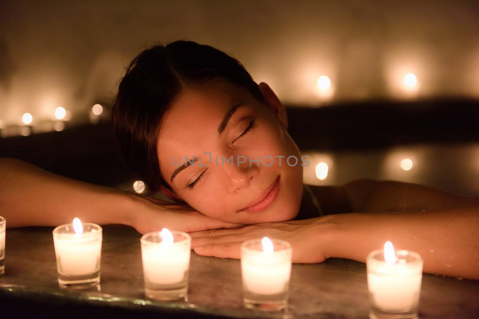 Beautiful Woman In Jacuzzi With Lit Candles At Spa by Maridav