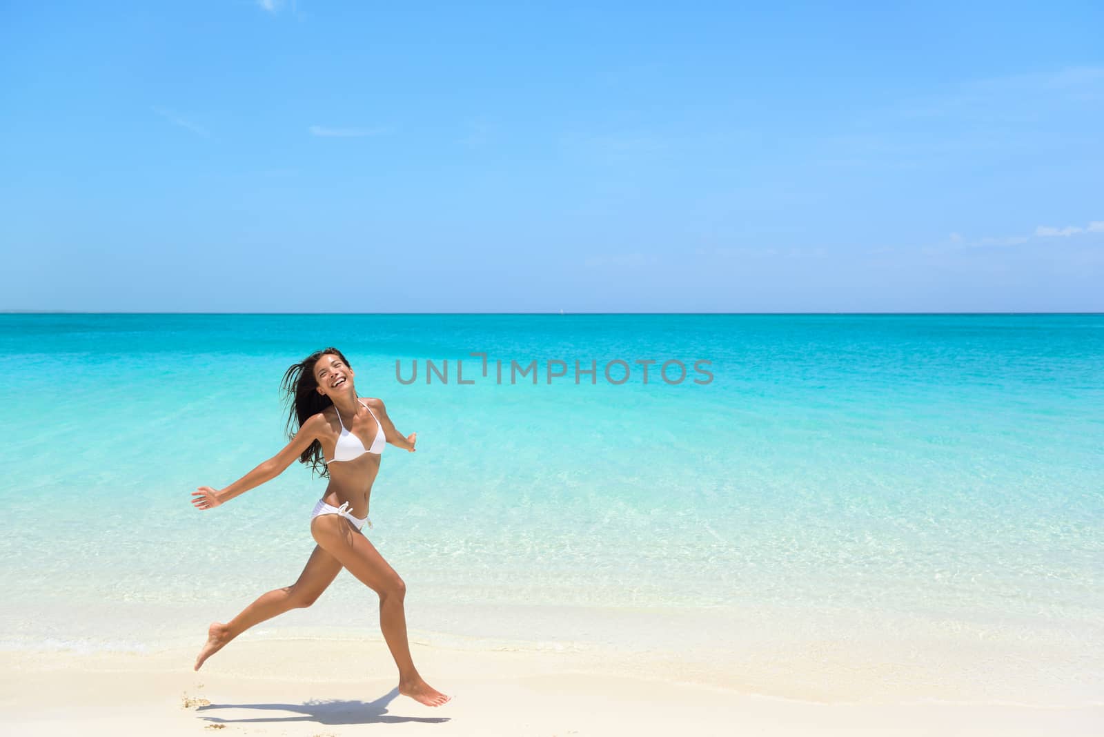 Carefree Woman Jumping On Beach during Summer by Maridav