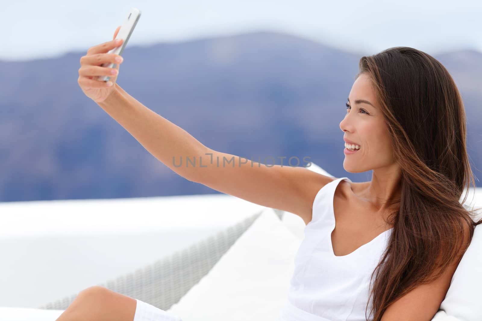 Happy Woman Taking Selfie On Sofa Outside by Maridav