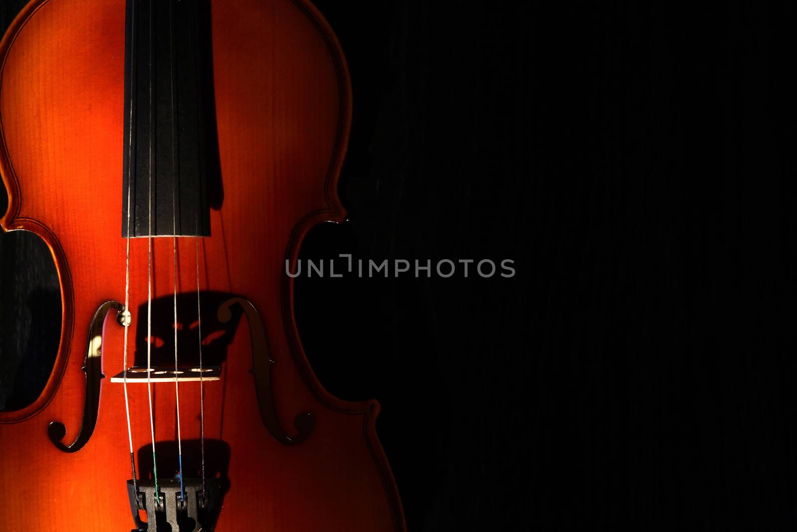 Nice violin closeup on black background under beam of light