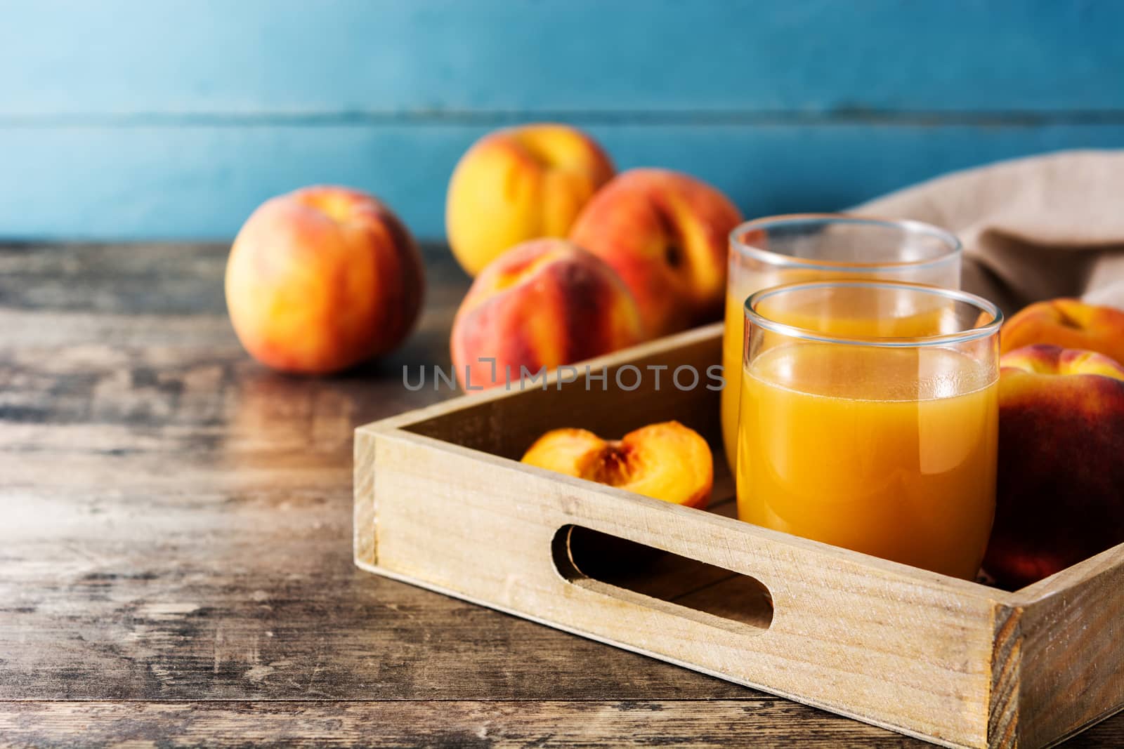 Natural peach juice in glass on wooden table