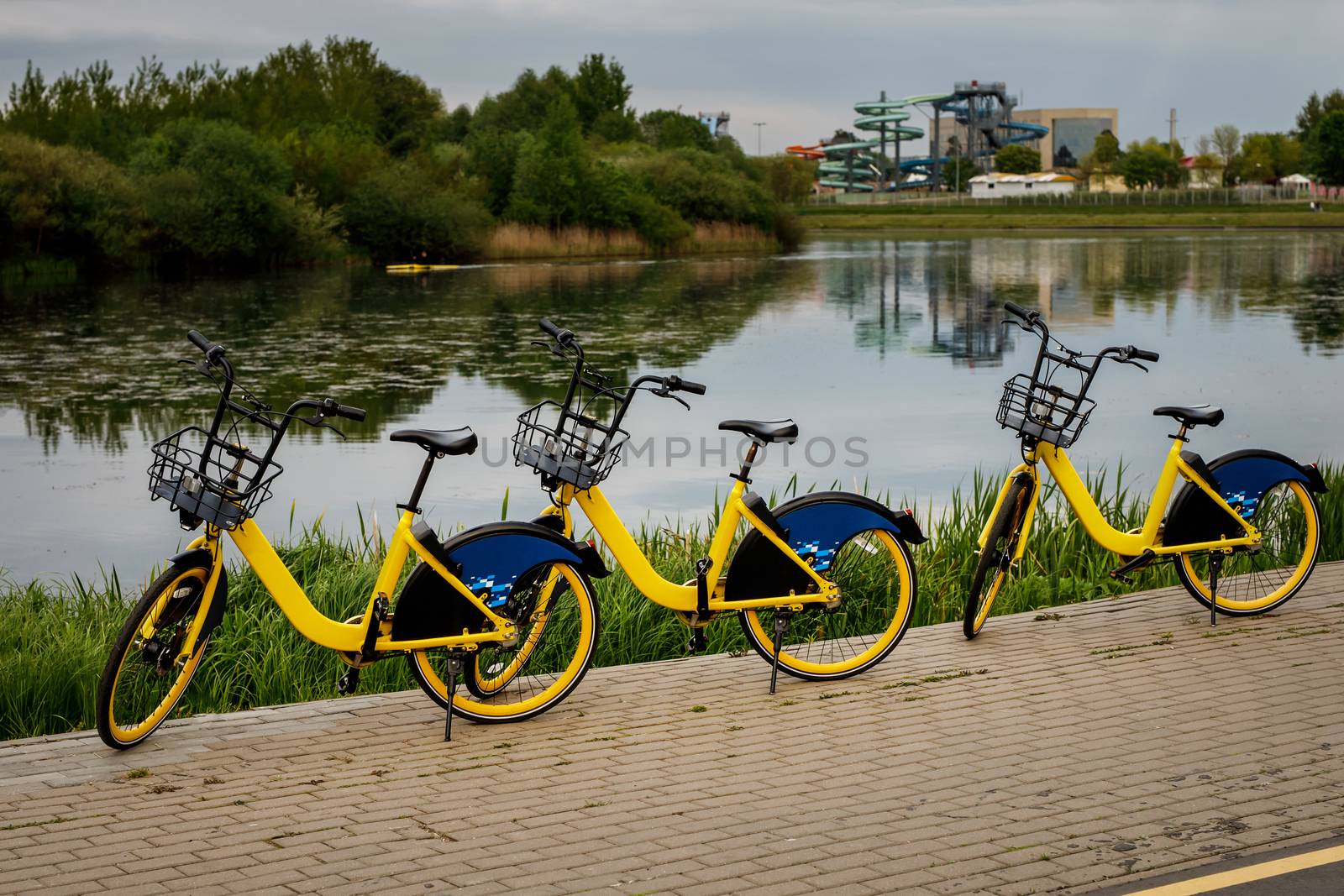 Two yellow city bikes by the lake by 9parusnikov