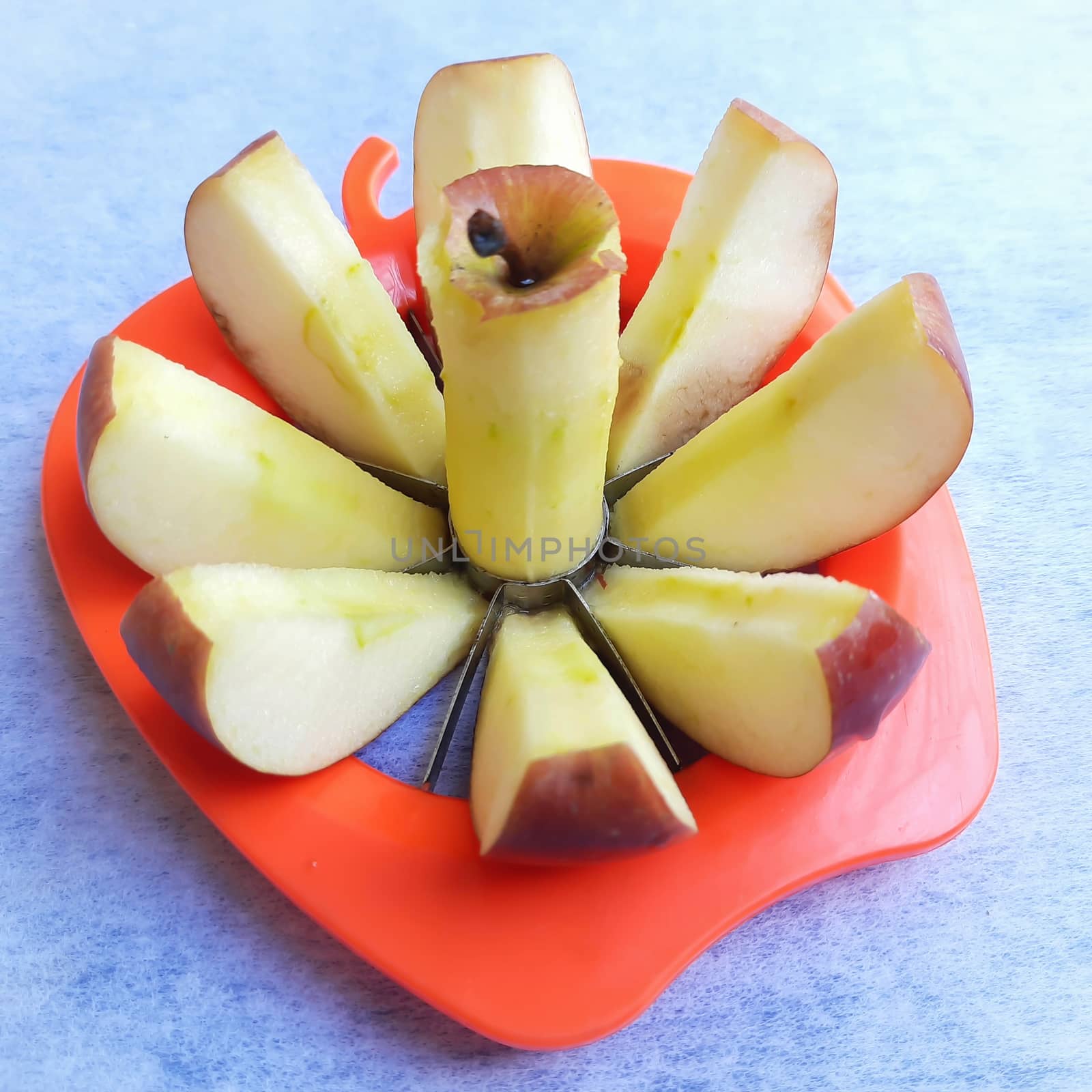 Apple shown beautifully in apple cutter like flower shape and it tempts to eat in white background