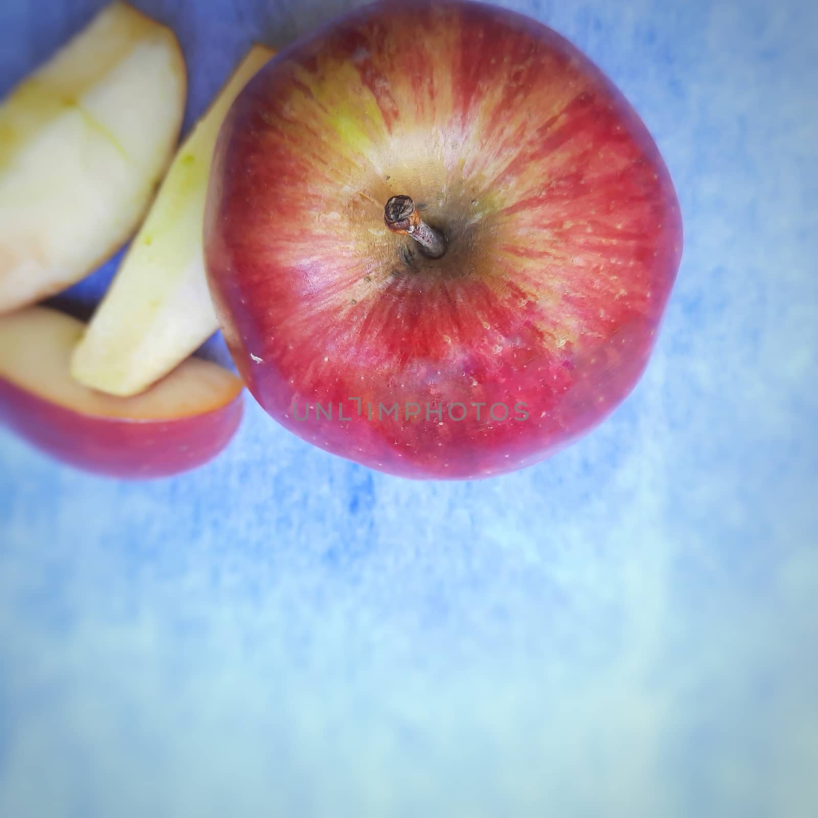 One apple and cut its pieces placed beautifully in white background